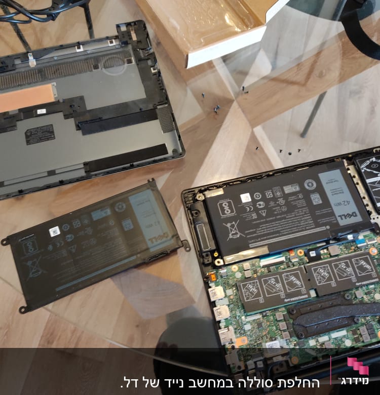 מחשב נייד פתוח עם סוללה ומעגלים חשמליים גלויים